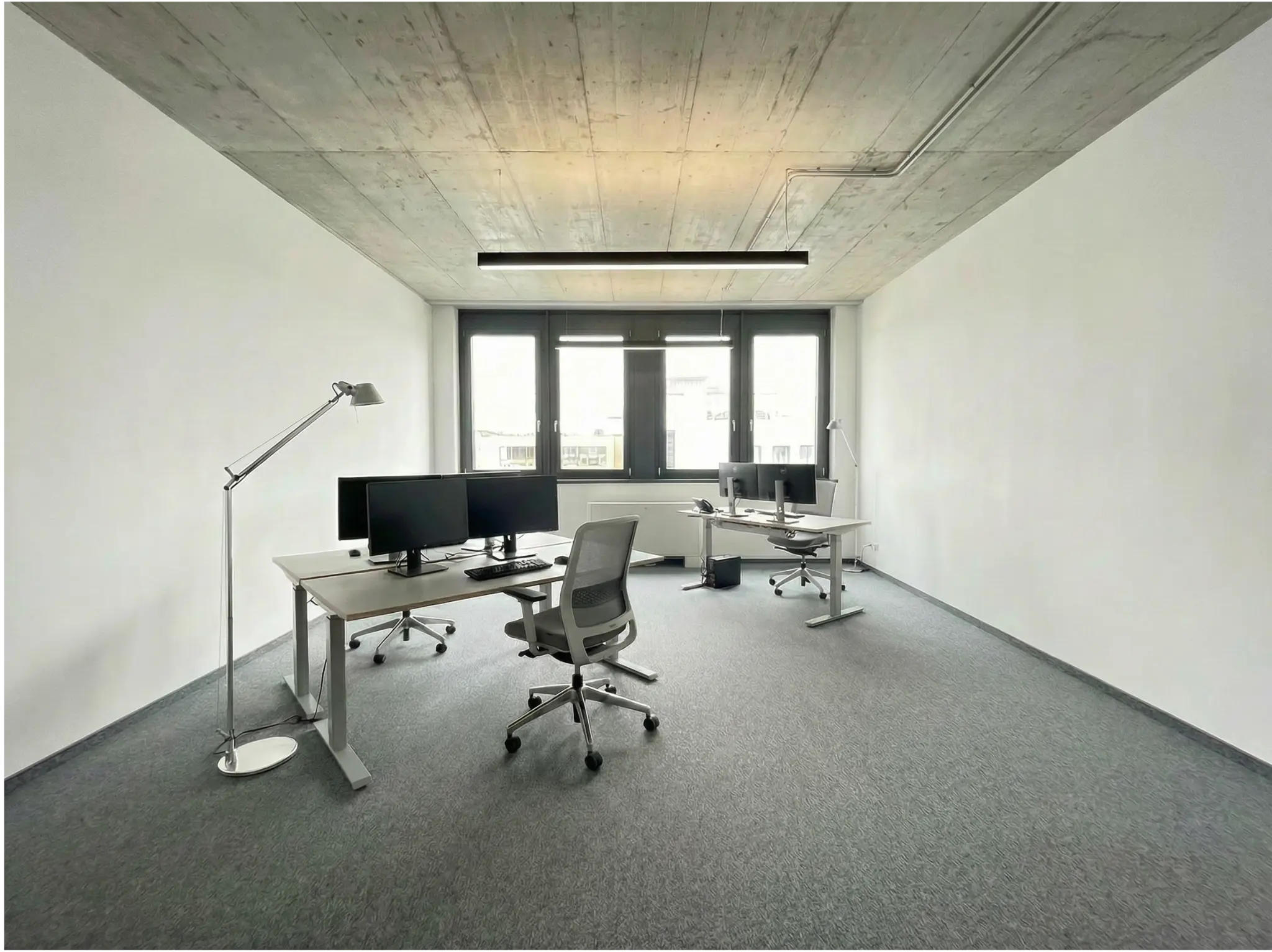 Loftbüro mit Sichtbeton-Decke und Linearleuchte